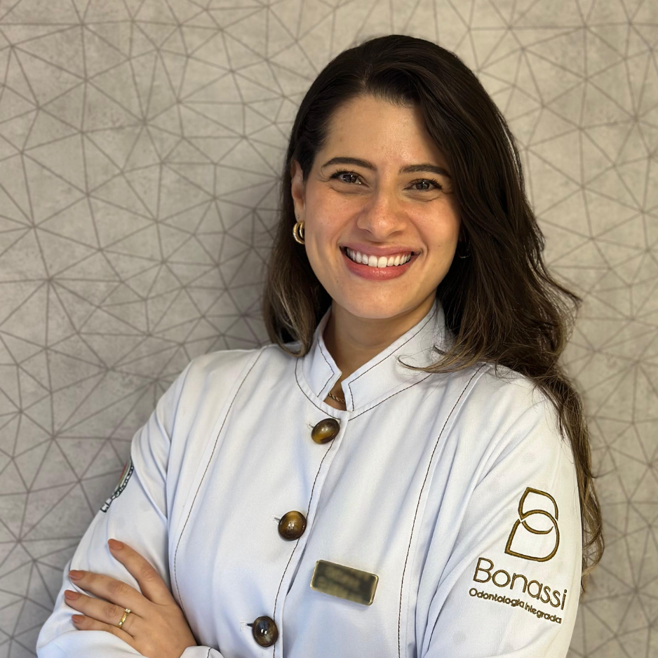 Doutora Ana usando jaleco branco e sorrindo com braços cruzados