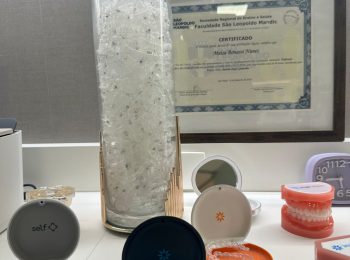 Vaso com diversos alinhadores Invisalign no centro do balcao, rodeados por 3 caixinhas para guardar os alinhadores