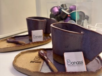 Duas conjuntos de xicaras de cafe com pires feitos de cerâmica nas cores lilás e terra